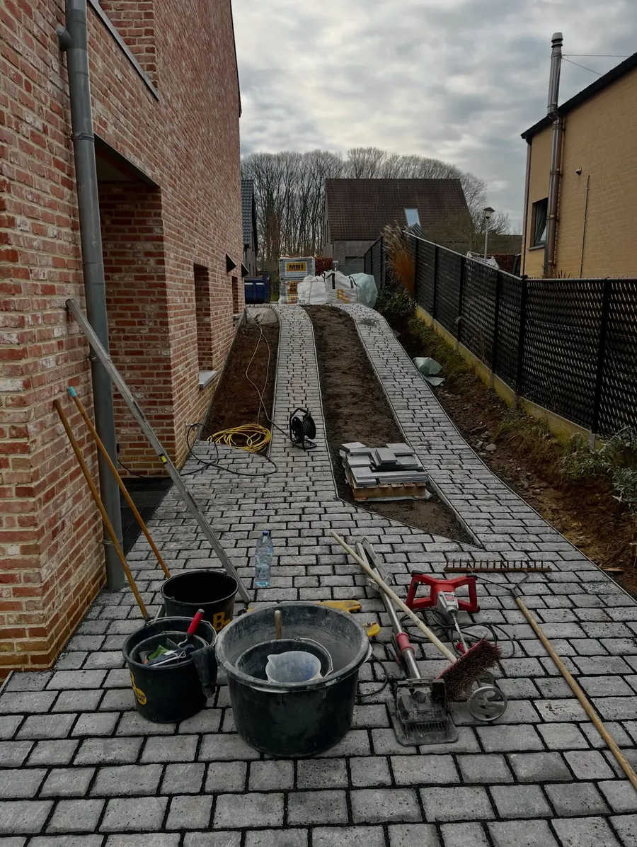 Aanleg van het klinkerpad naast de woning